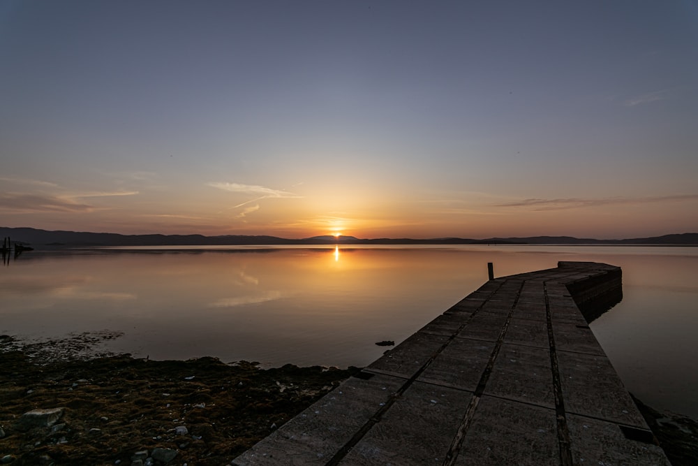 Muelle de hormigón gris sobre el mar durante la puesta de sol