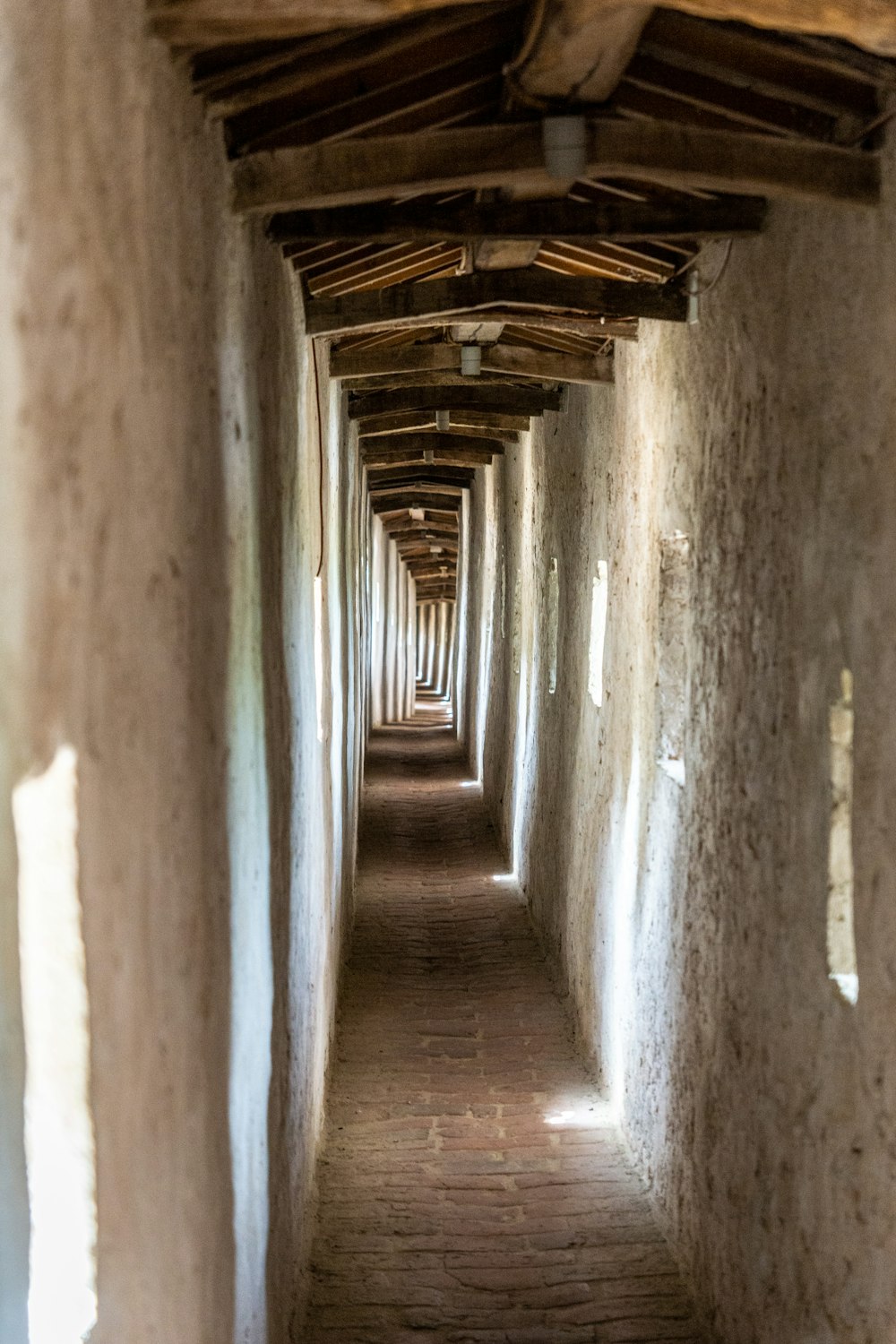 brown wooden pathway in between concrete walls