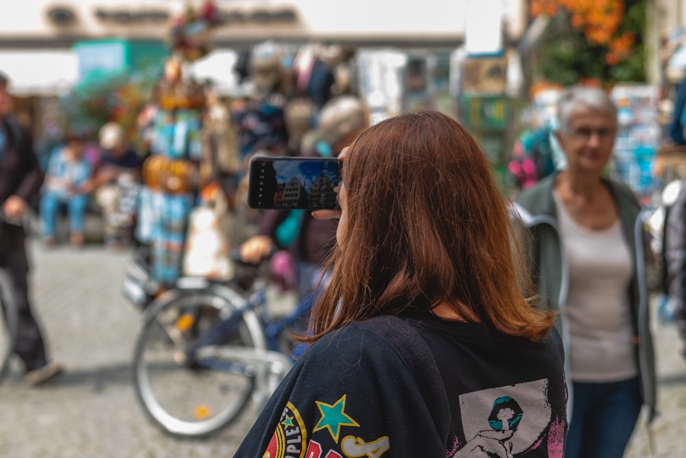 woman in black and white shirt standing near bicycle