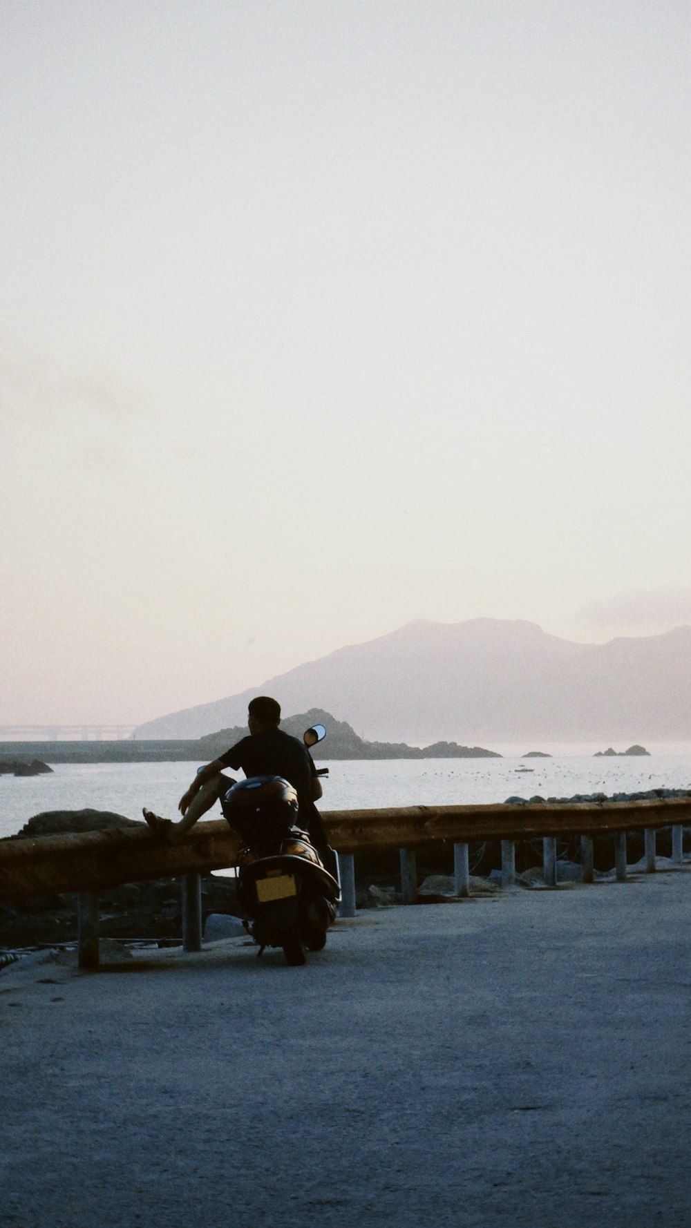 man and woman sitting on bench near sea during daytime