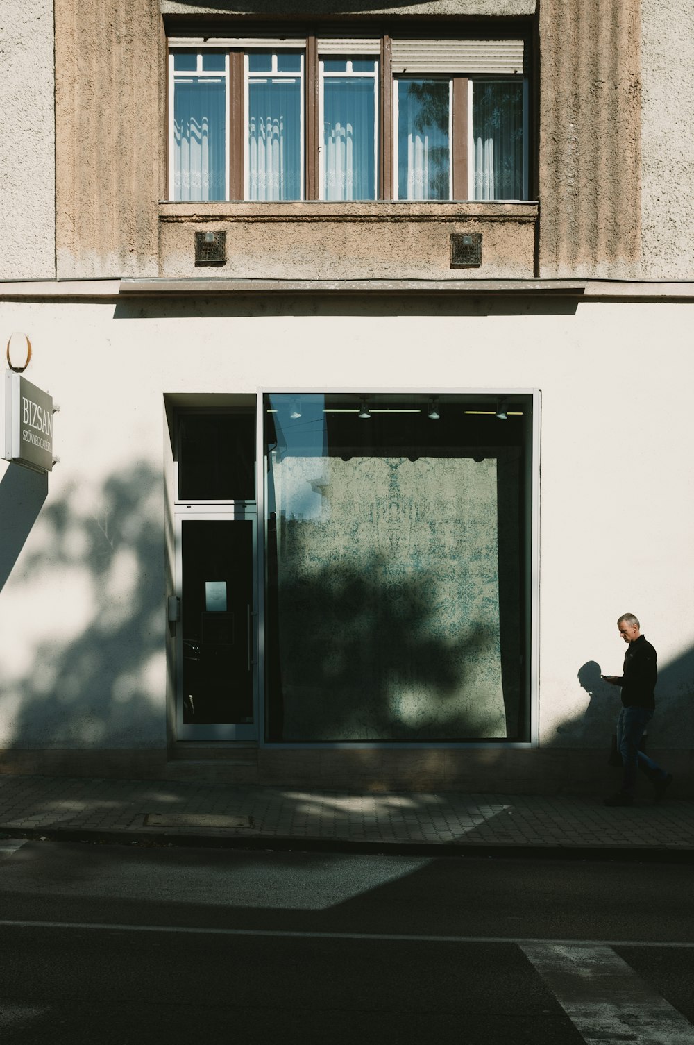 man in black jacket walking on sidewalk during daytime