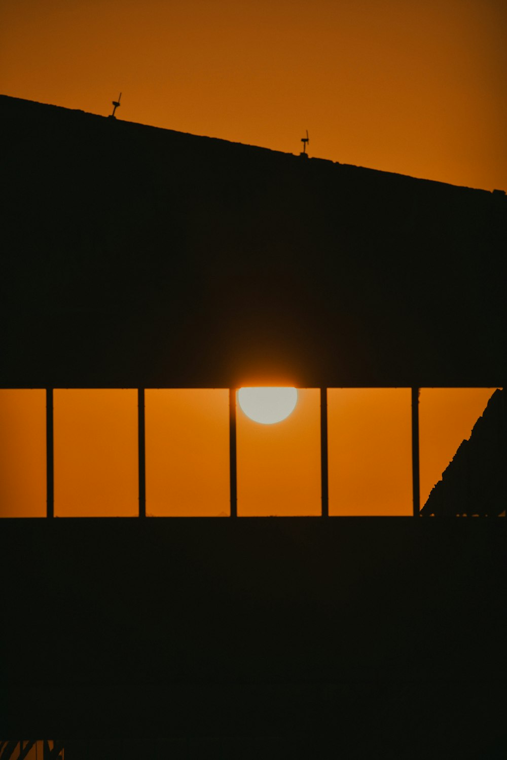 silhouette of man standing on the window during sunset