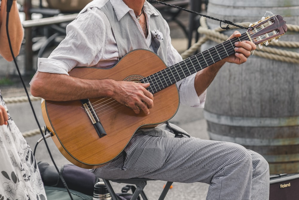 man in white dress shirt playing guitar