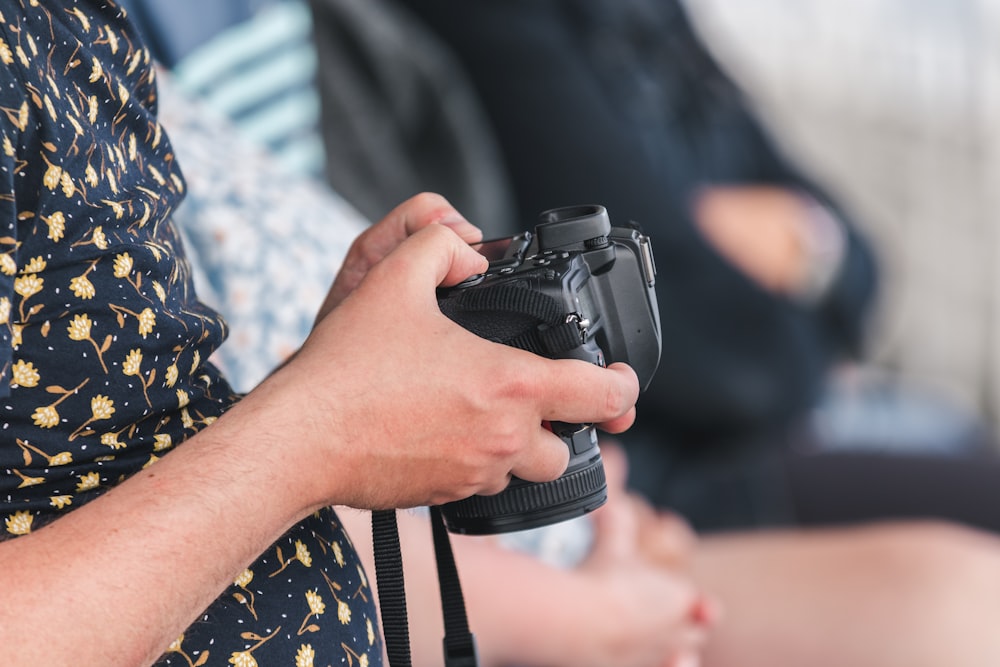 person holding black dslr camera