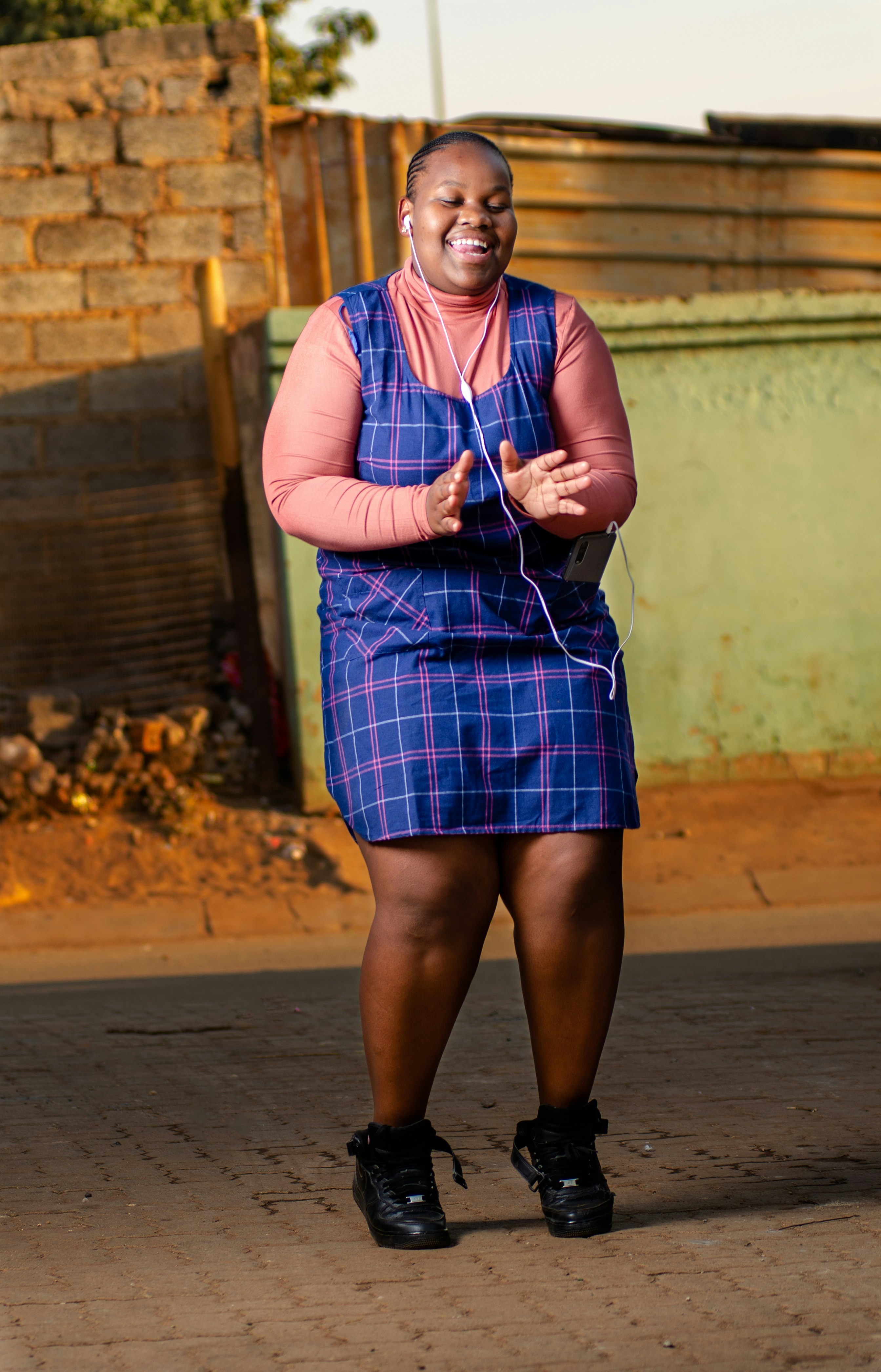 woman in red and blue plaid dress standing on pathway