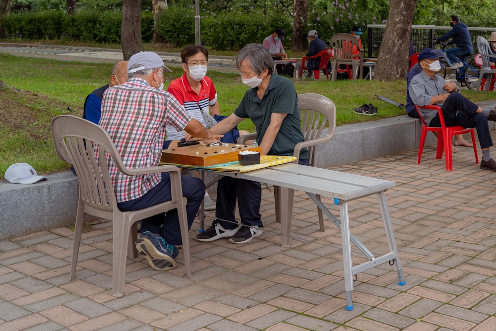 man and woman sitting on white metal chairs