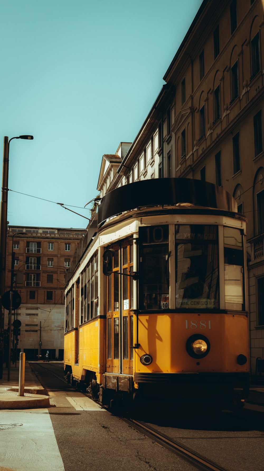 yellow and white tram in the city during daytime