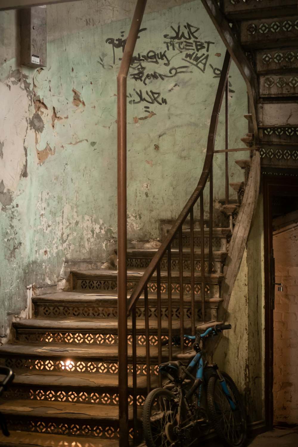 brown wooden staircase near blue bicycle