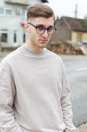 man in white crew neck sweater wearing black framed eyeglasses