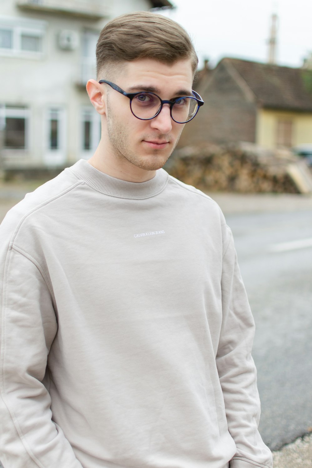 man in white crew neck sweater wearing black framed eyeglasses