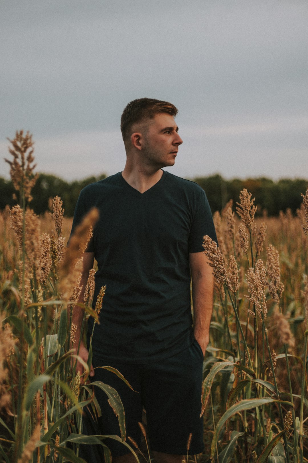 man in black crew neck t-shirt standing on green grass field during daytime