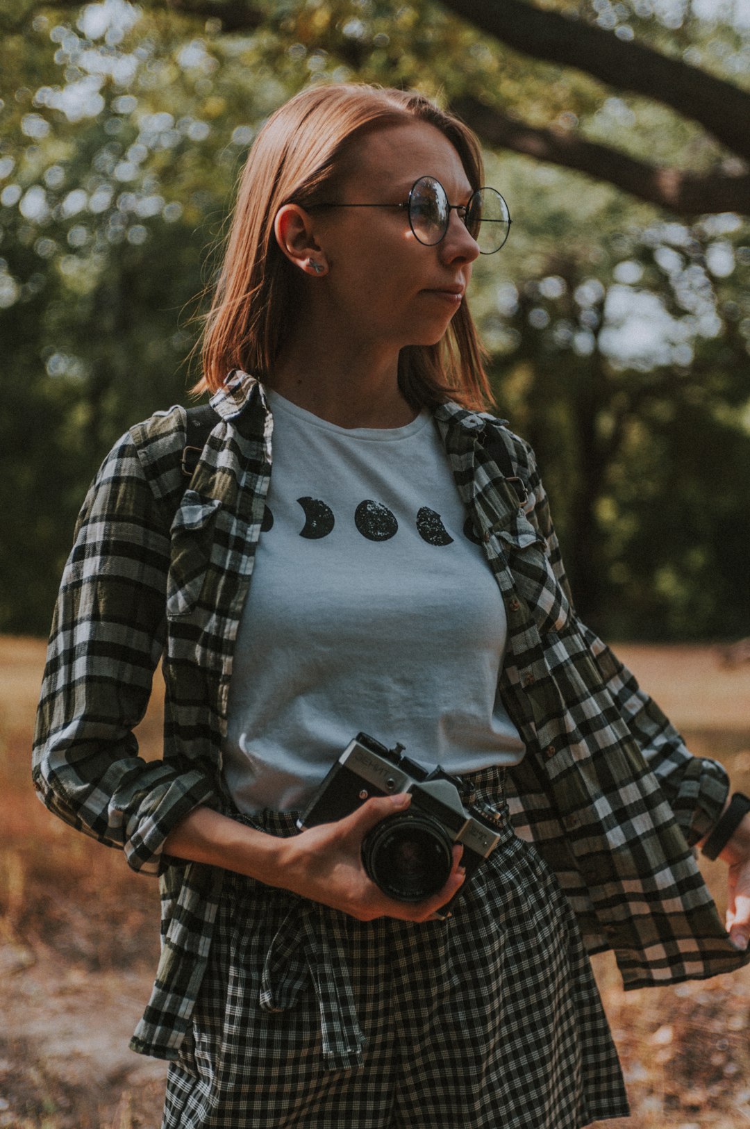 woman in white tank top holding black camera