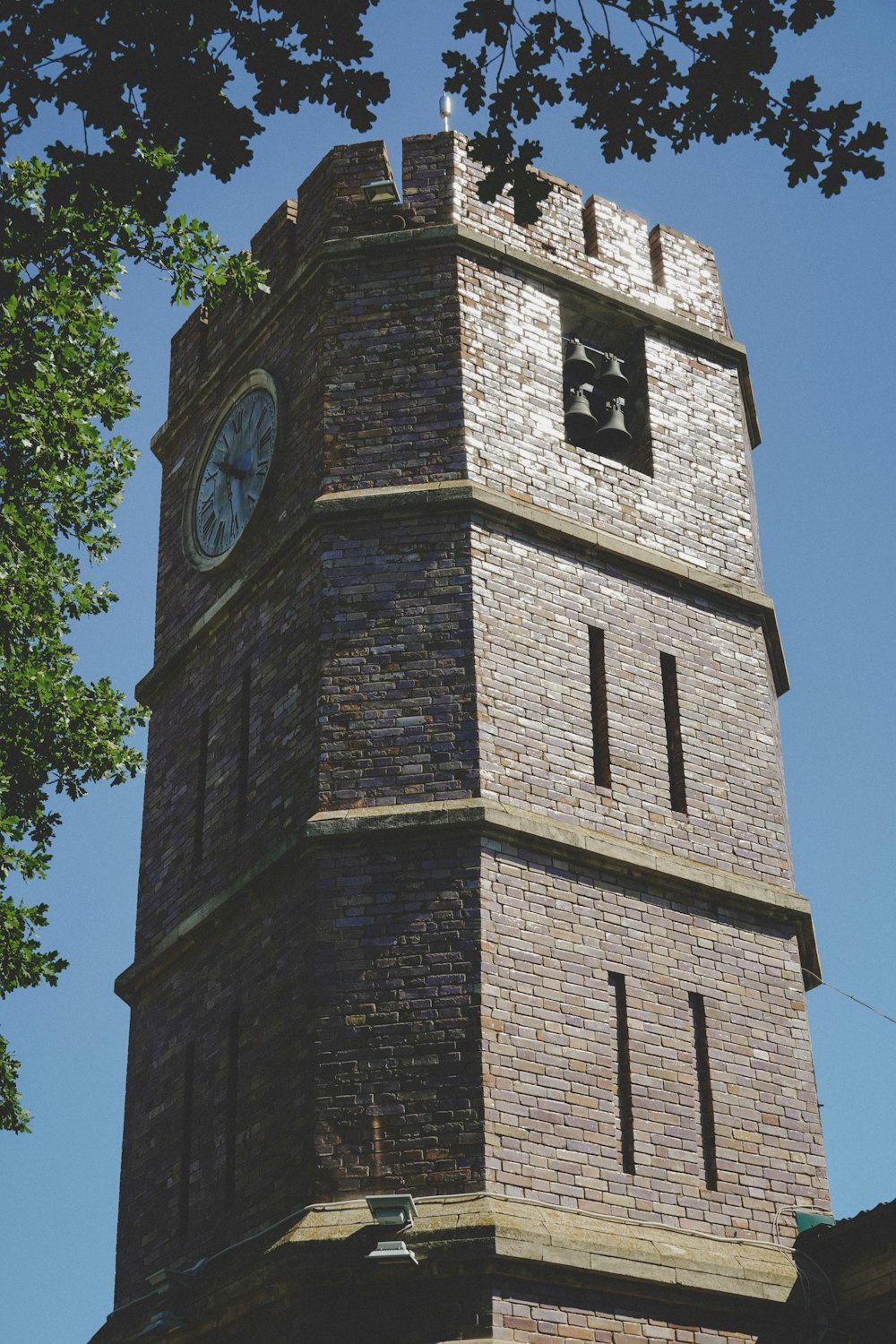 Torre in mattoni marroni con orologio analogico