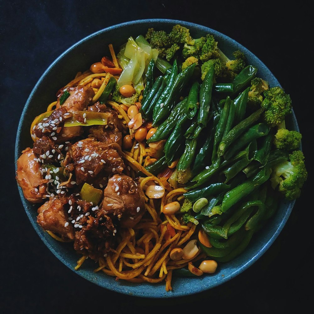 a blue bowl filled with meat and veggies