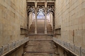 brown wooden staircase in between brown concrete walls