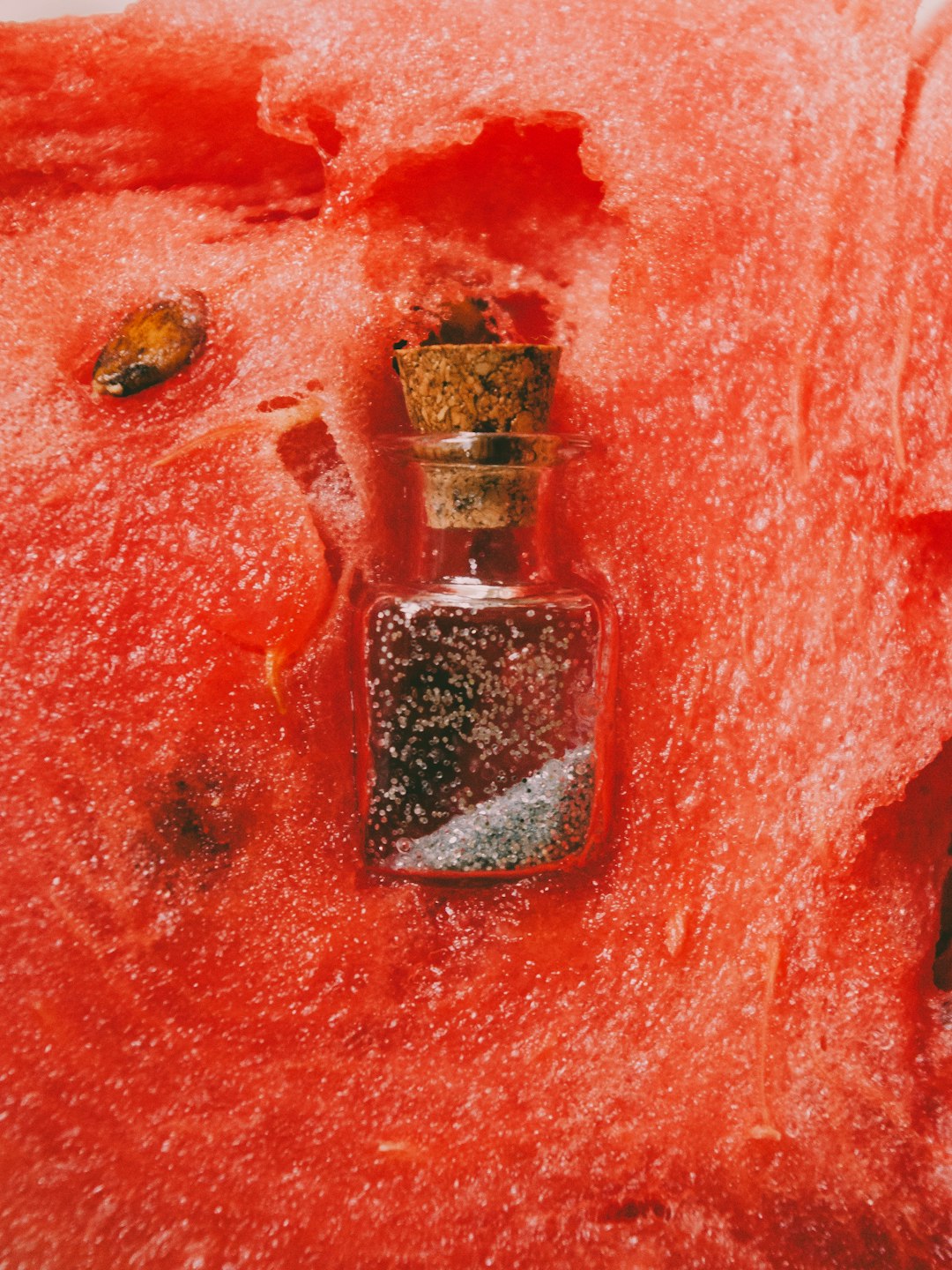 clear glass bottle on red surface