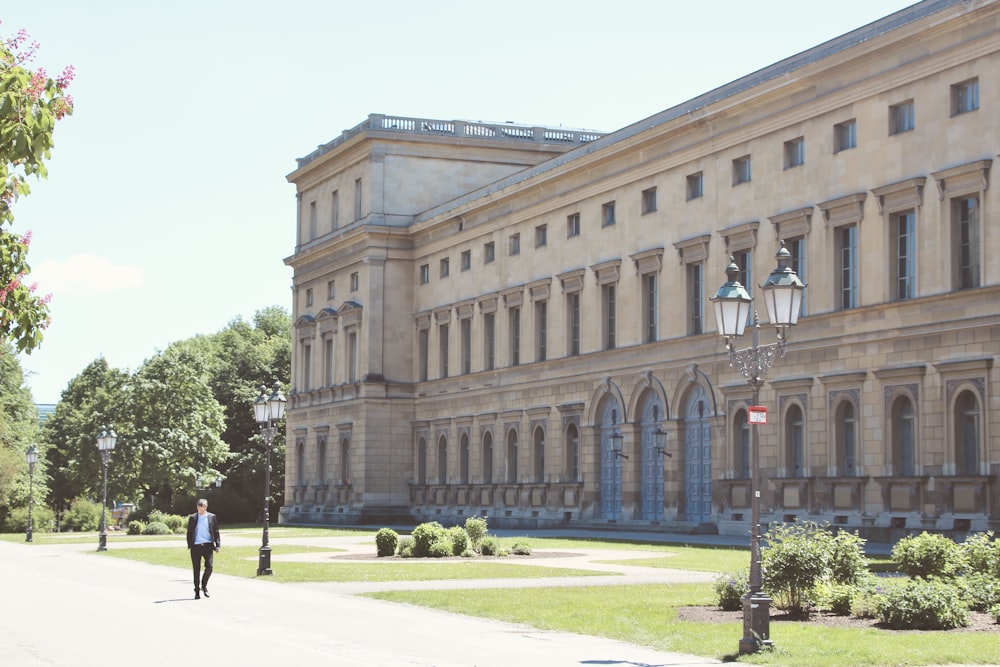 people walking on pathway near brown concrete building during daytime