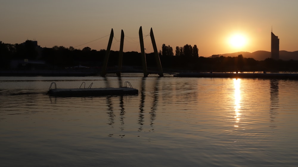 silhouette of boat on sea during sunset