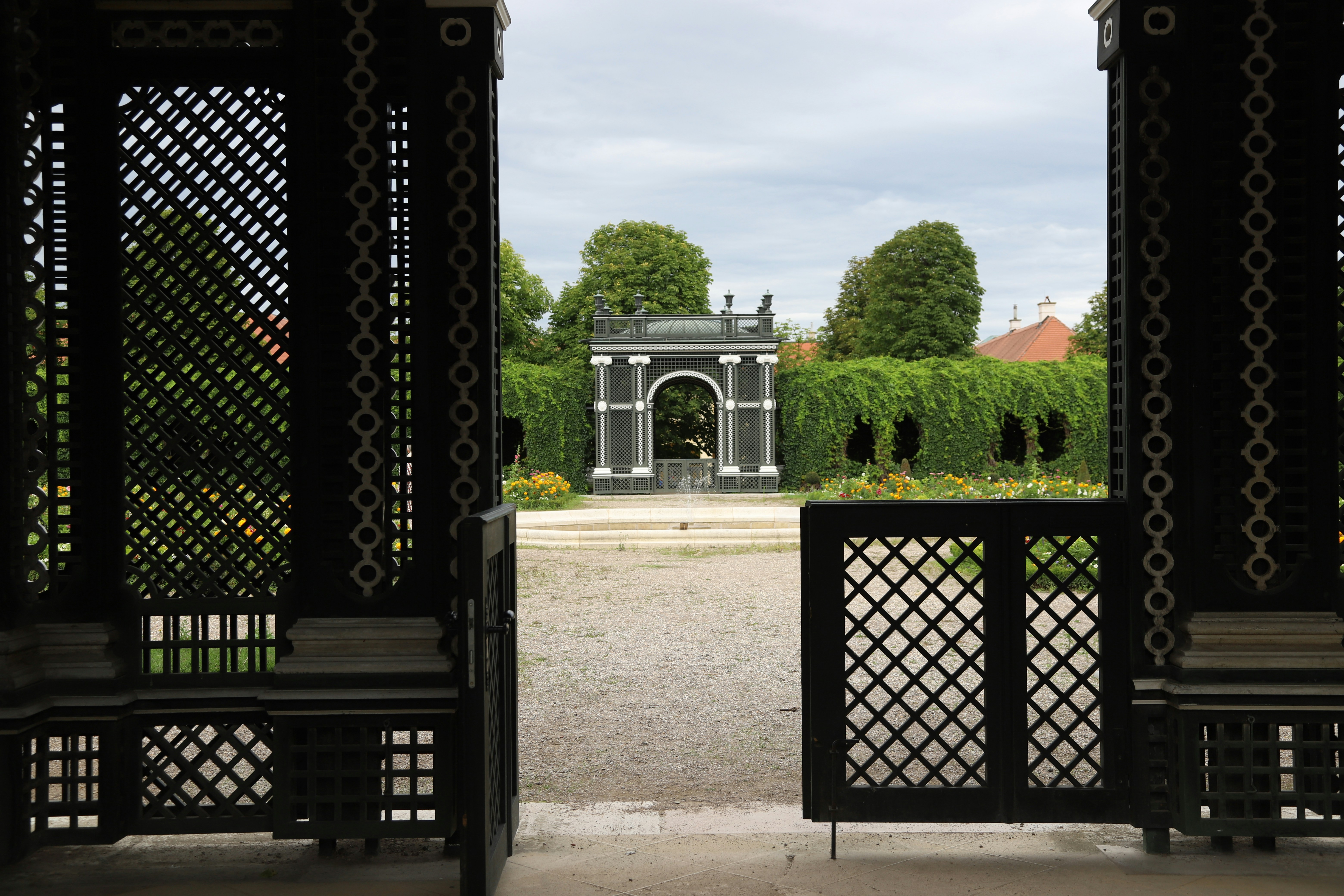 black metal gate near green trees during daytime
