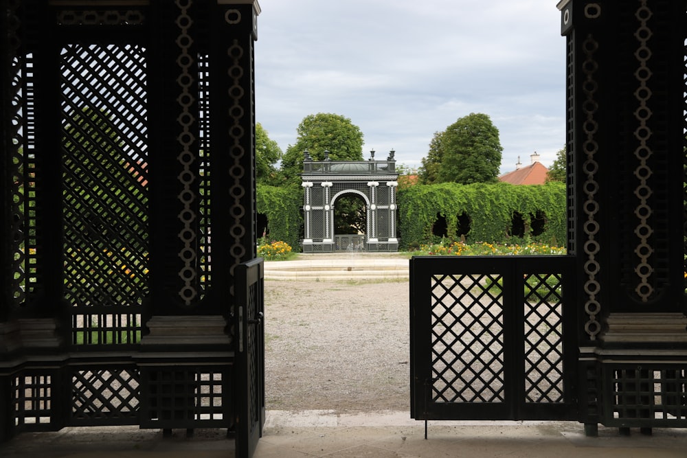 black metal gate near green trees during daytime