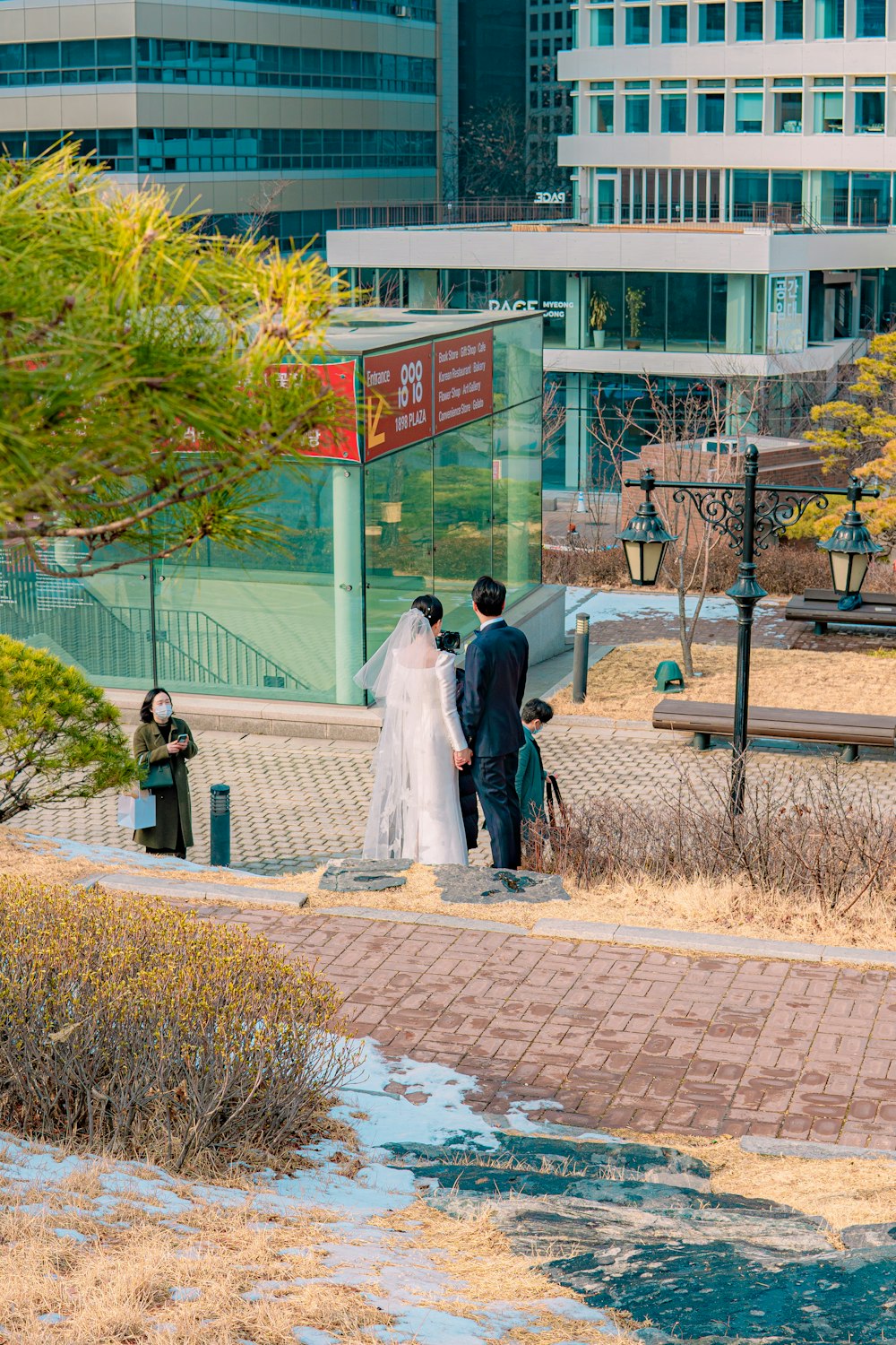 woman in white wedding gown walking on sidewalk during daytime
