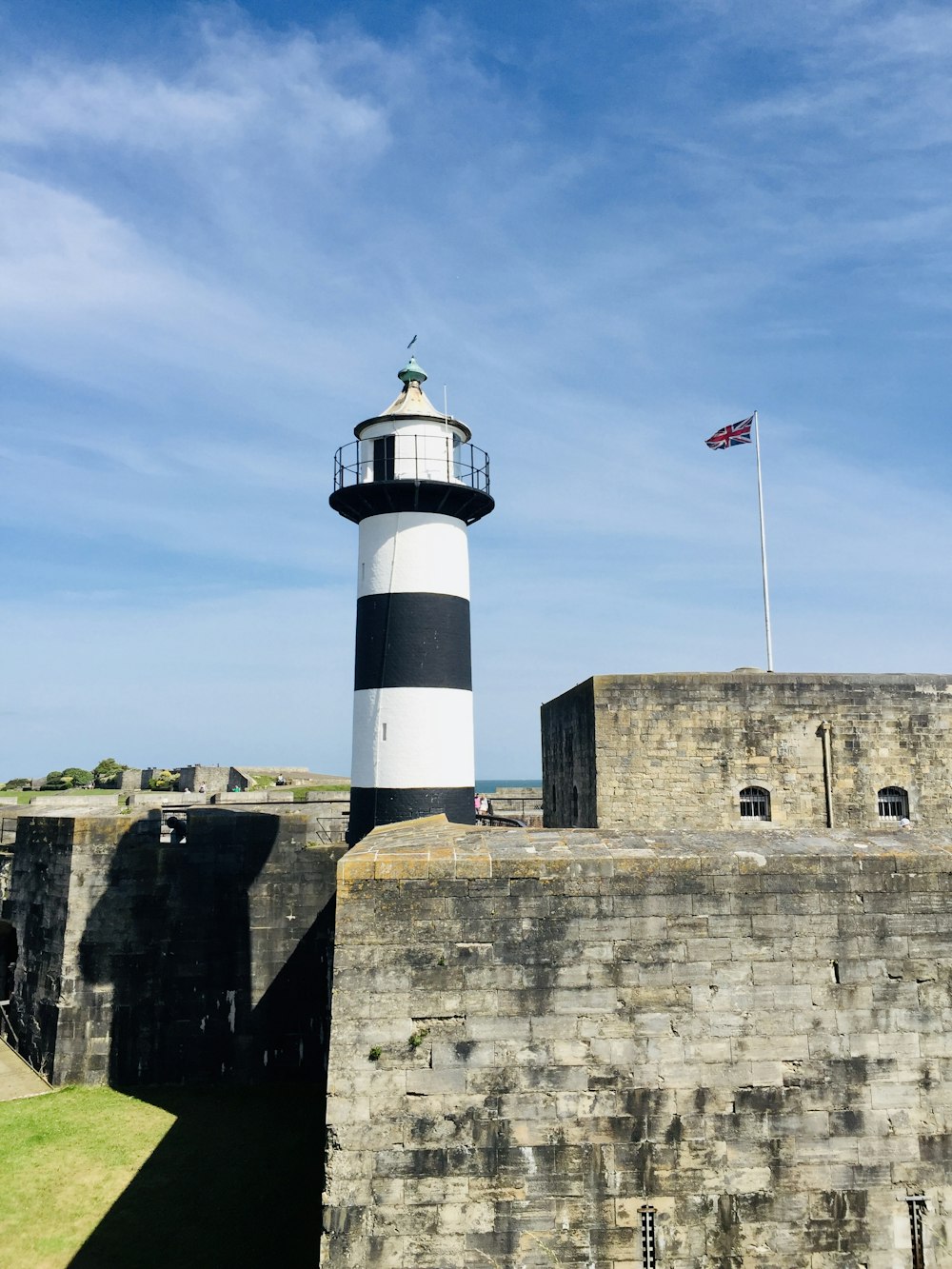 white and brown concrete lighthouse under blue sky during daytime