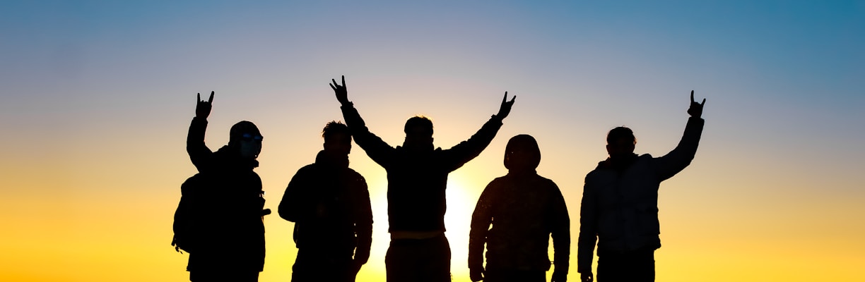 silhouette of people raising their hands