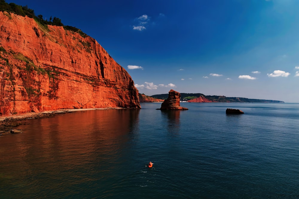 brown rock formation beside body of water during daytime