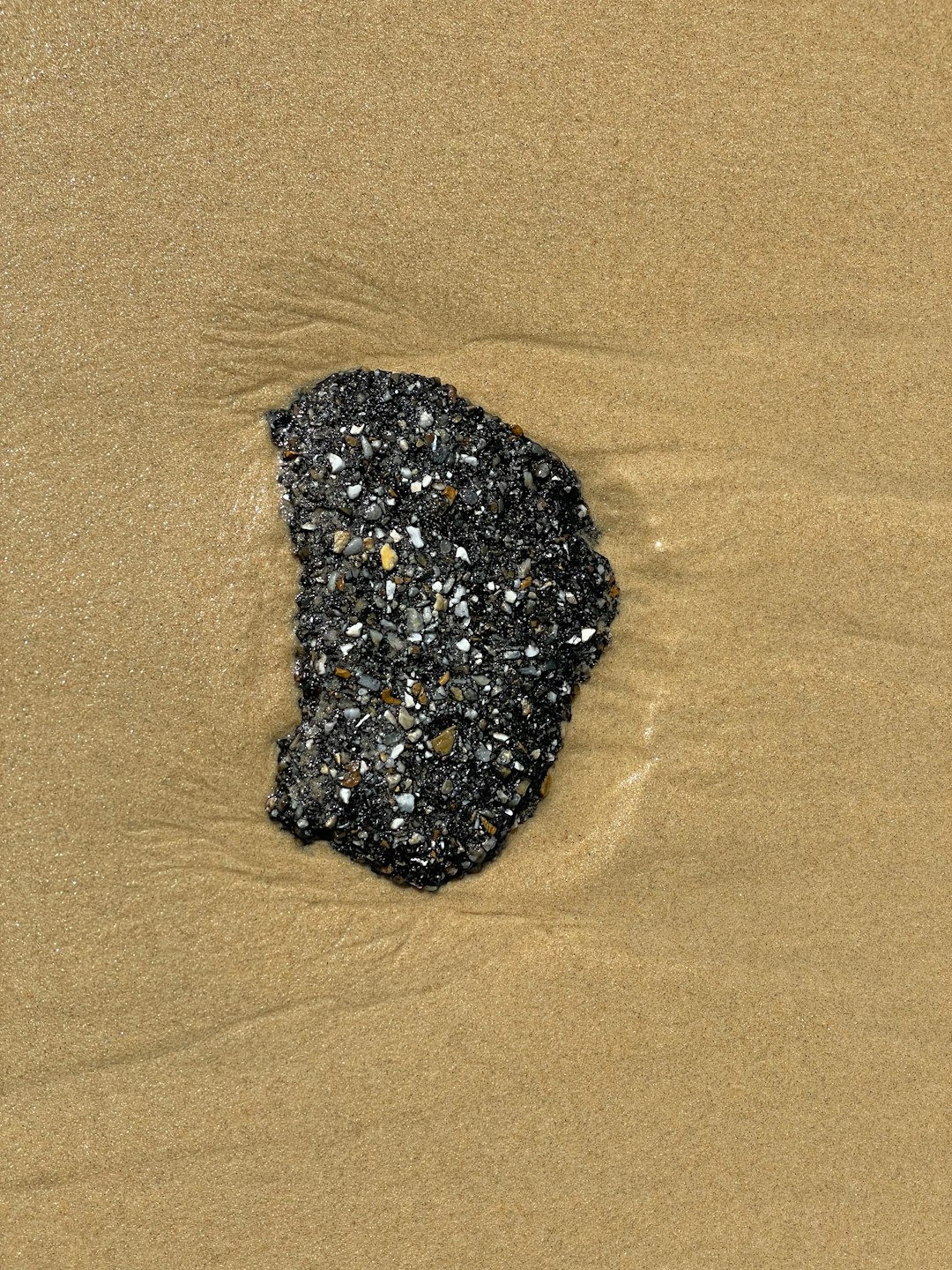 black and white stone on brown sand
