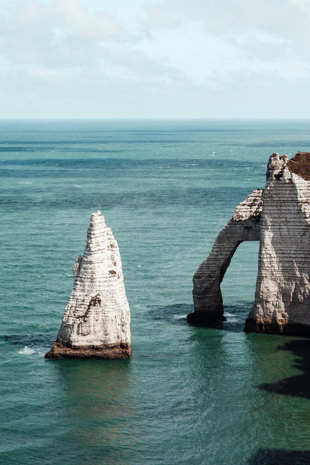 white and brown rock formation on blue sea during daytime