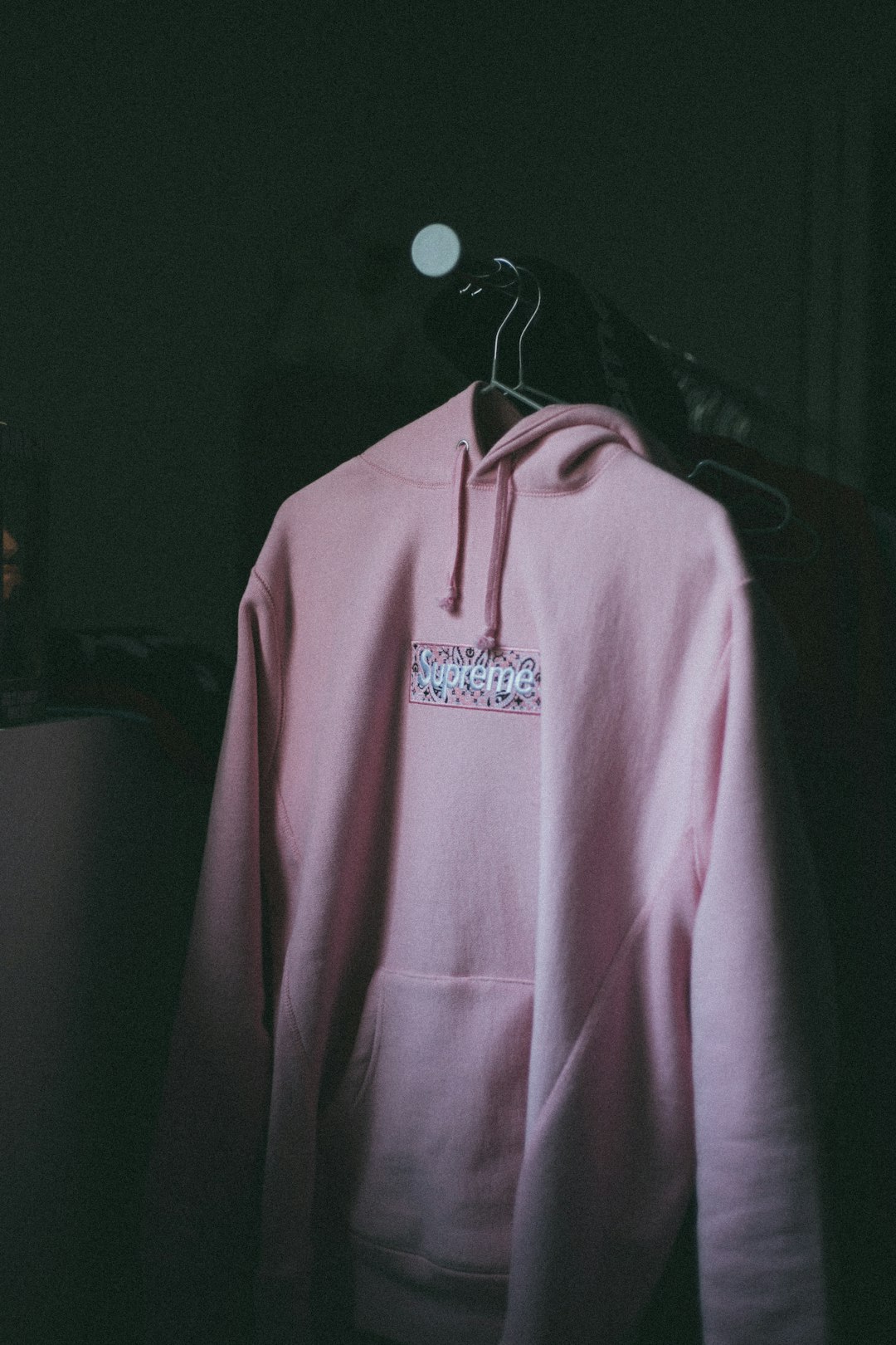 pink pullover hoodie on black clothes hanger