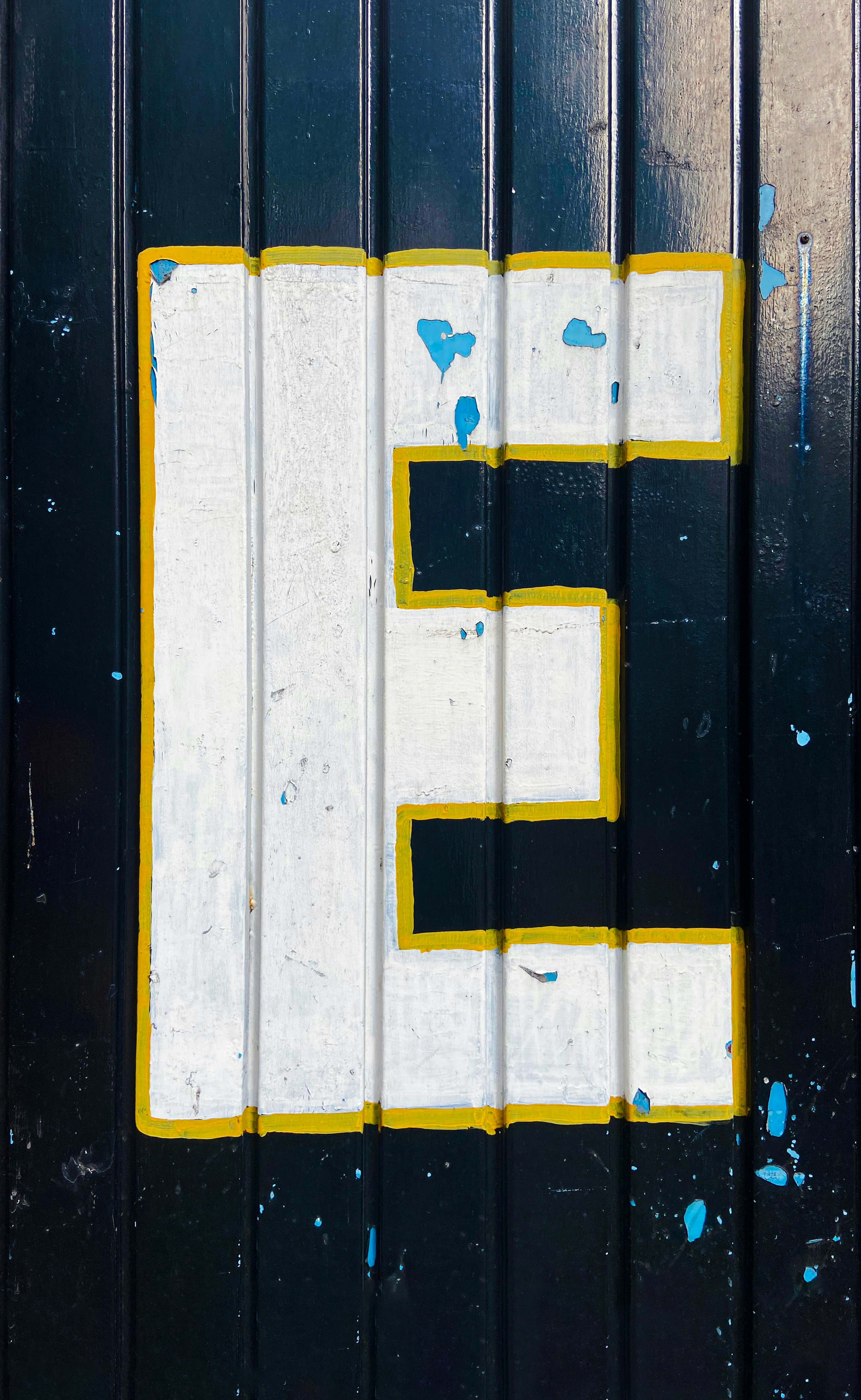 black textured door with withe E hand painted letter.