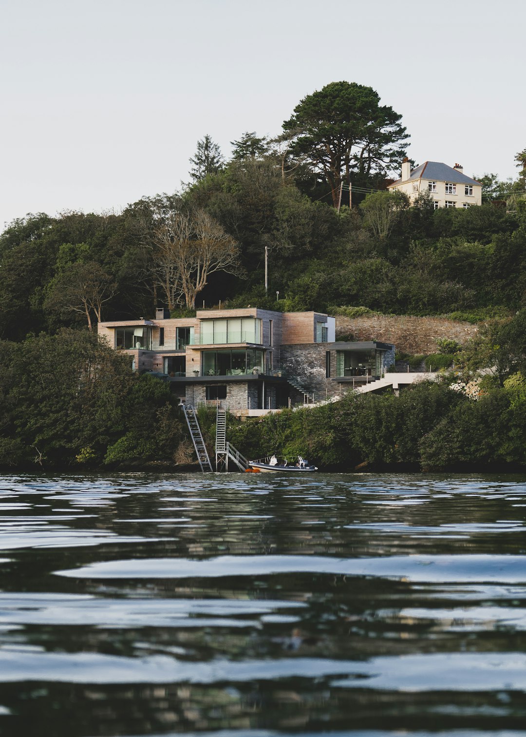 white and brown concrete building near green trees and river during daytime