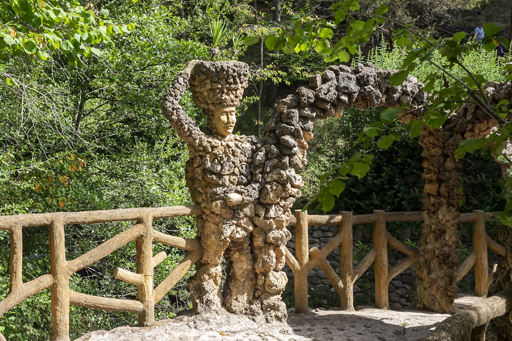 brown concrete statue near green trees during daytime