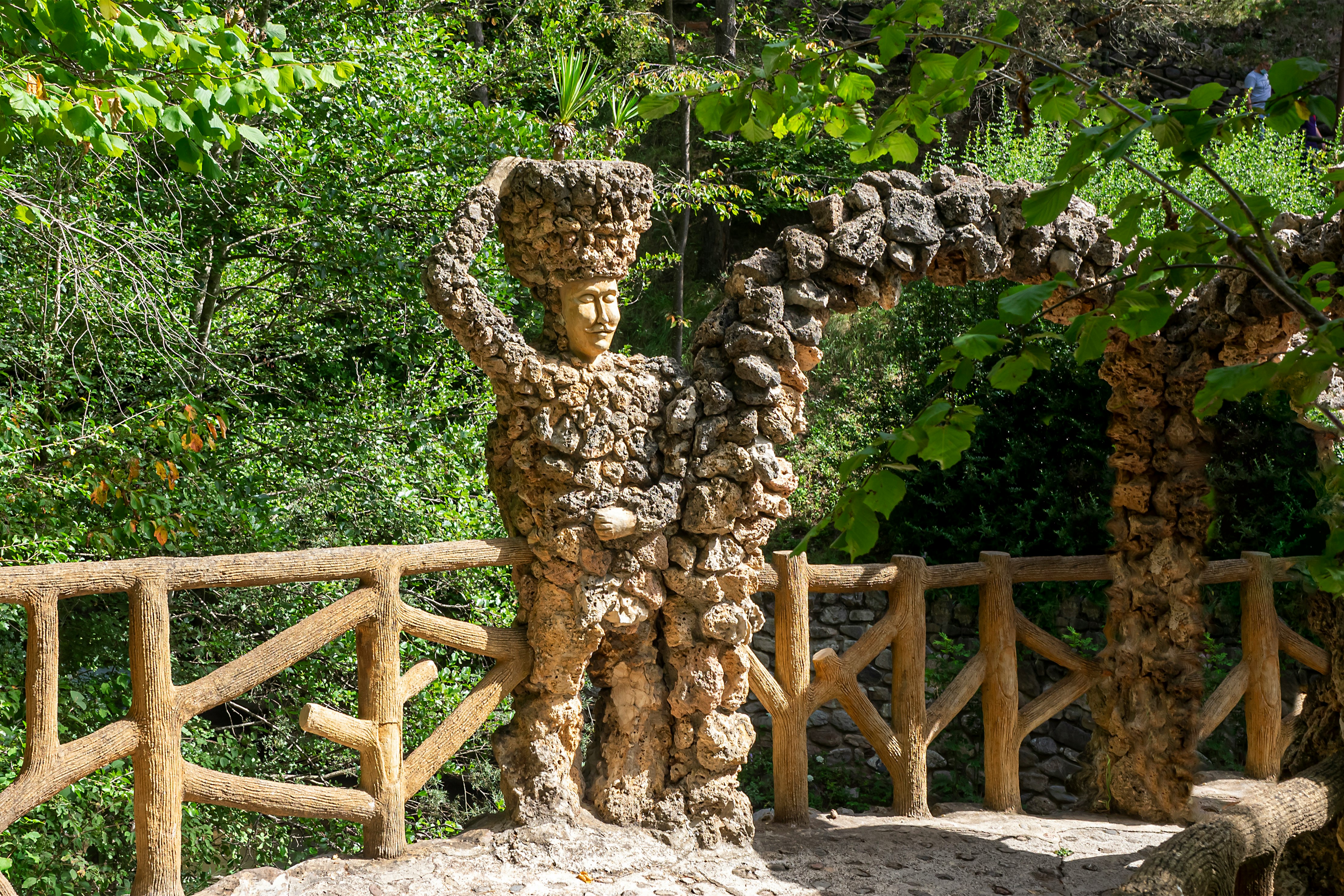 brown concrete statue near green trees during daytime