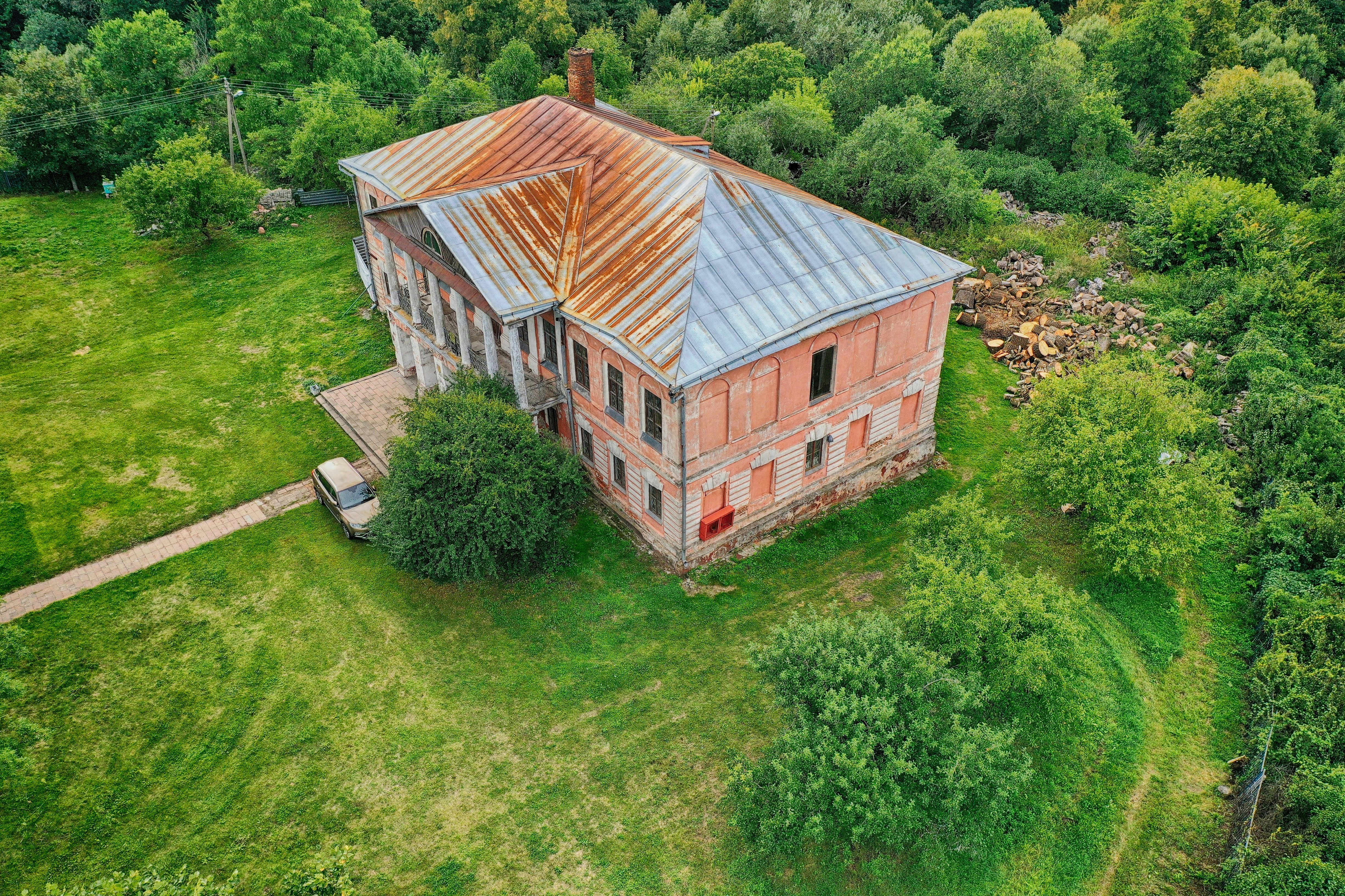 brown and white wooden house surrounded by green trees during daytime