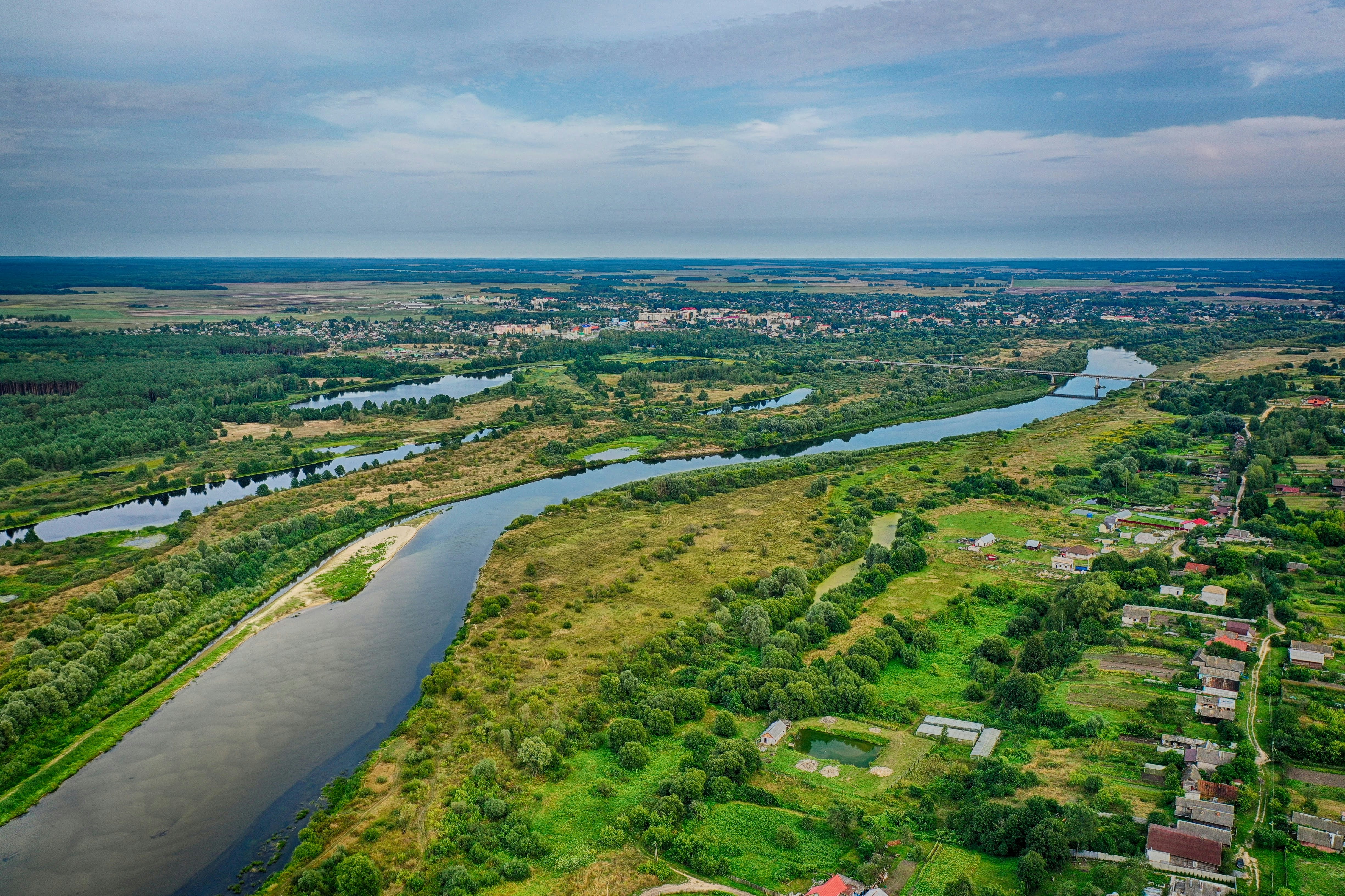 aerial view of green grass field near body of water during daytime