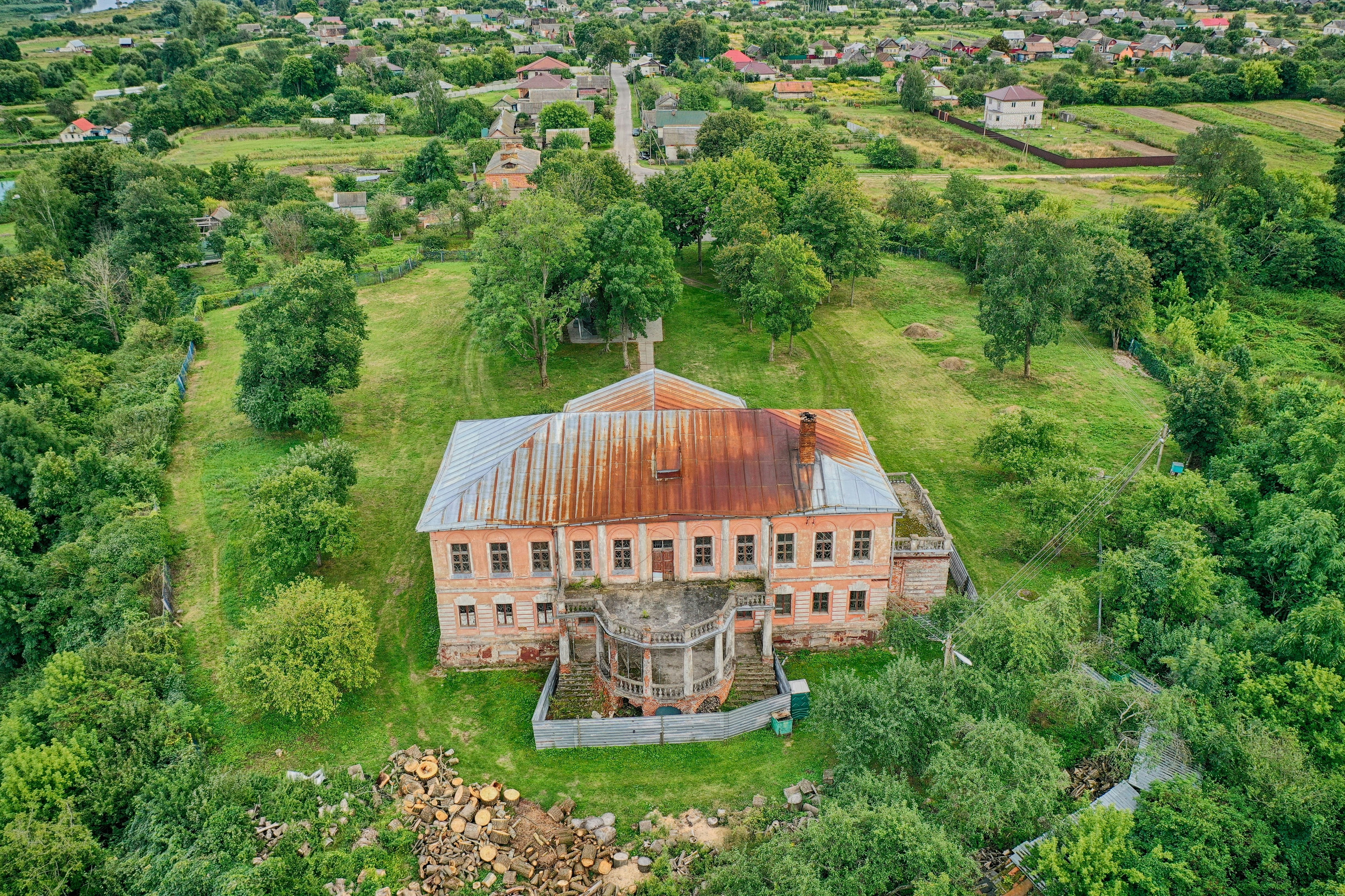 brown and white house surrounded by green trees during daytime