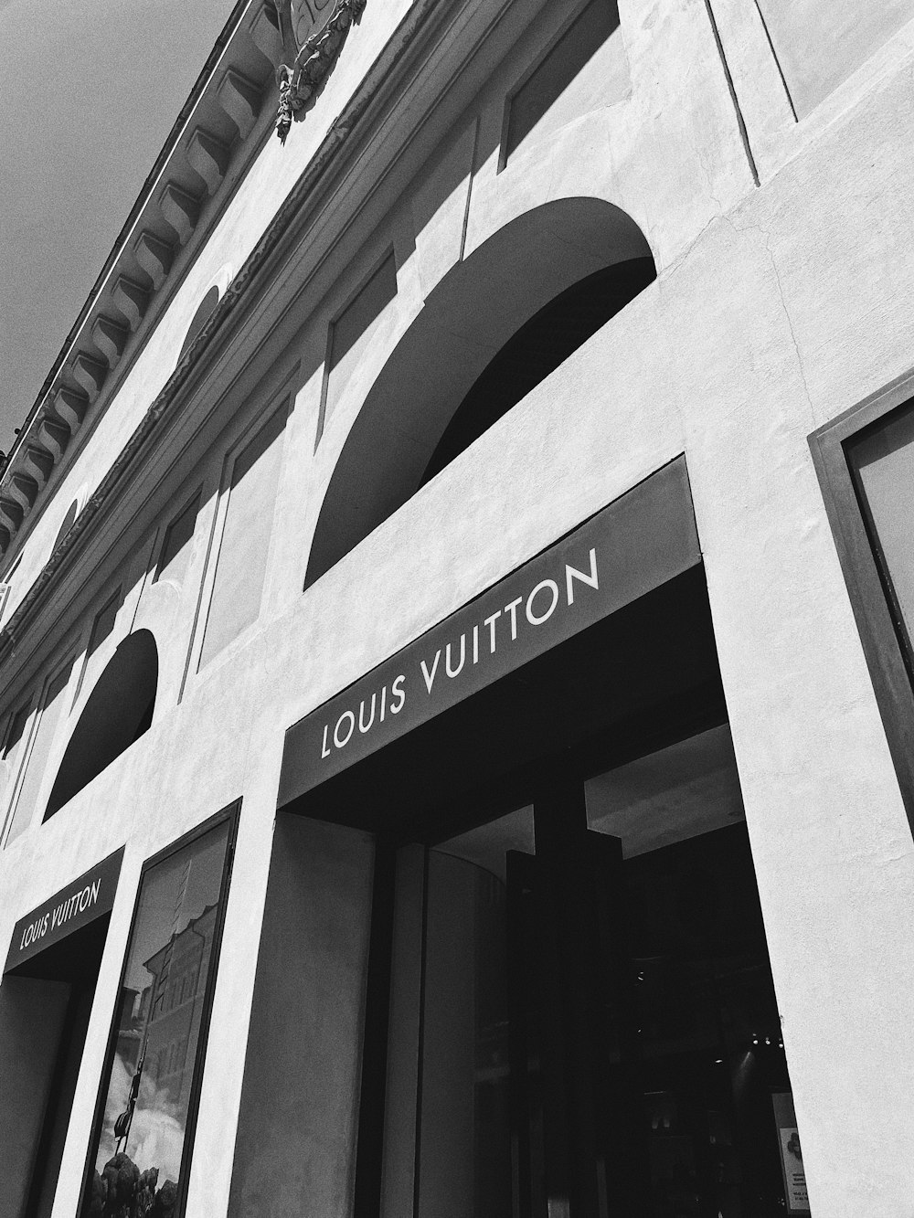 a black and white photo of a louis vuitton store
