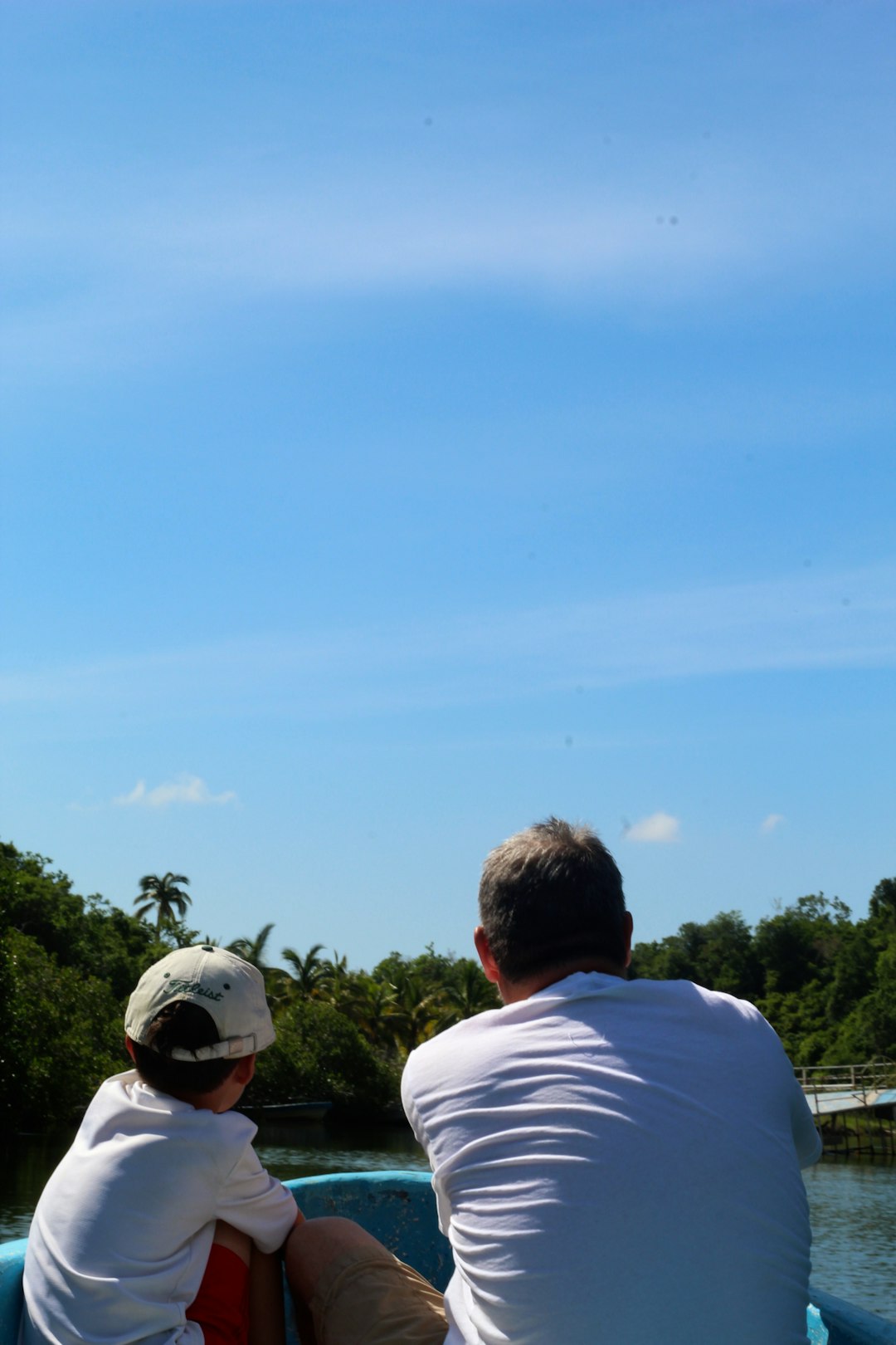 man in white shirt sitting on grass field during daytime