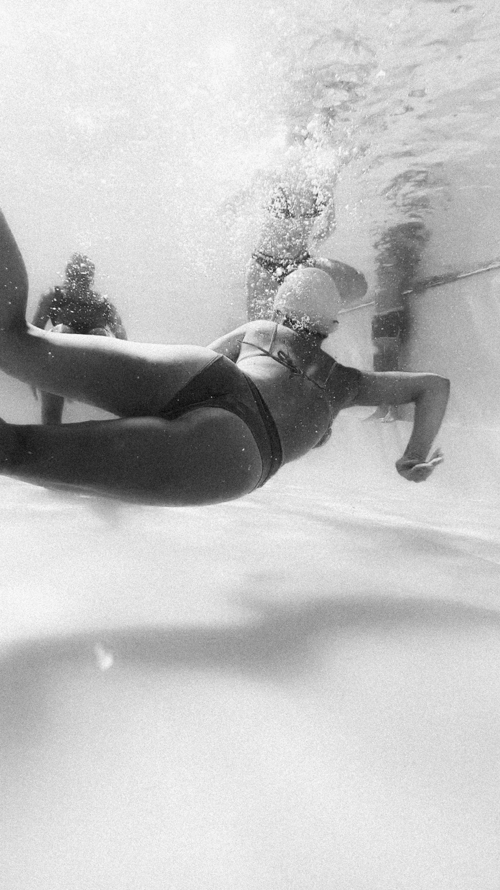 woman in black bikini lying on white floor