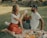 A happy older couple enjoying a picnic in a sunny park.