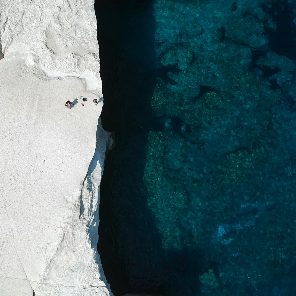 person in white shirt standing on white sand beach during daytime