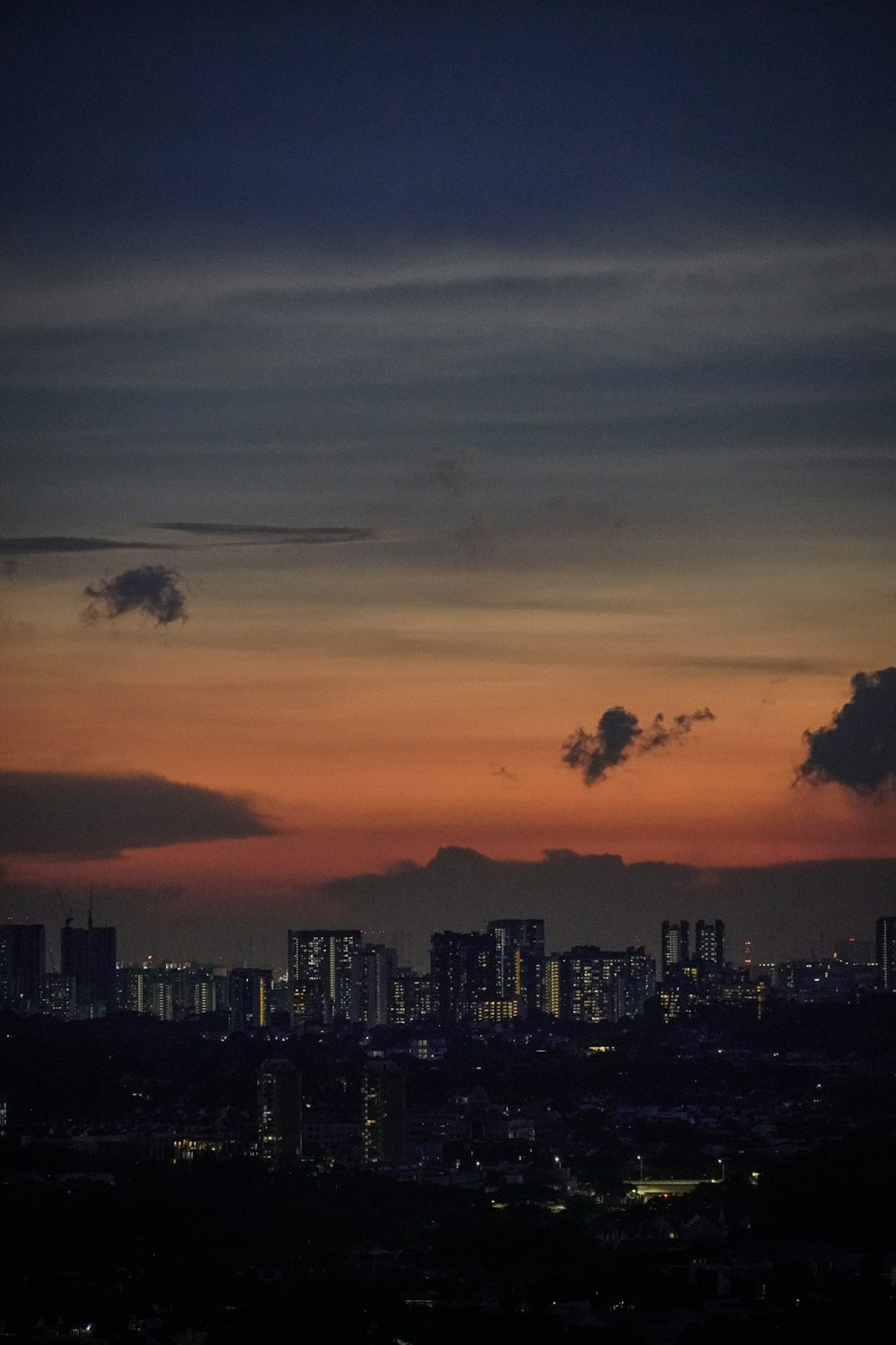 city skyline under orange and blue cloudy sky during sunset