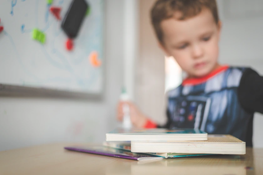boy in blue and red polo shirt sitting at the table
