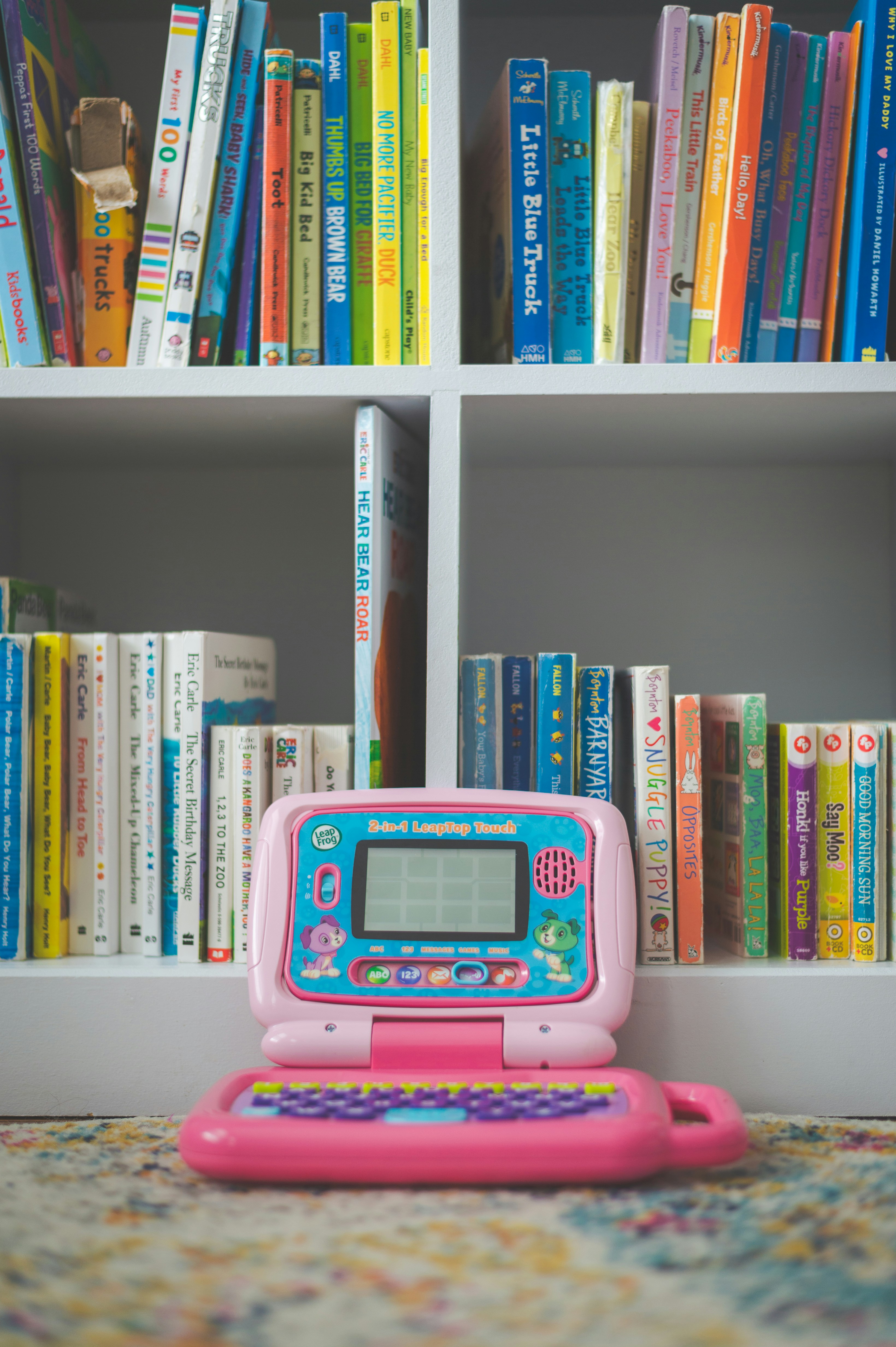 pink and white digital device on white wooden shelf
