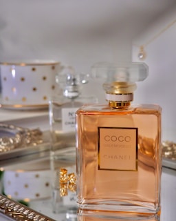 clear glass perfume bottle on white table