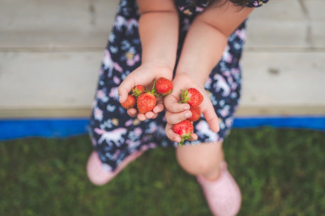 person holding red strawberries on lap