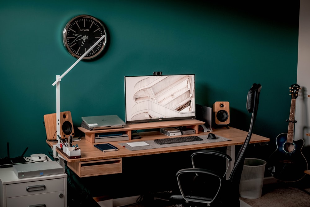 black and silver speaker on brown wooden desk