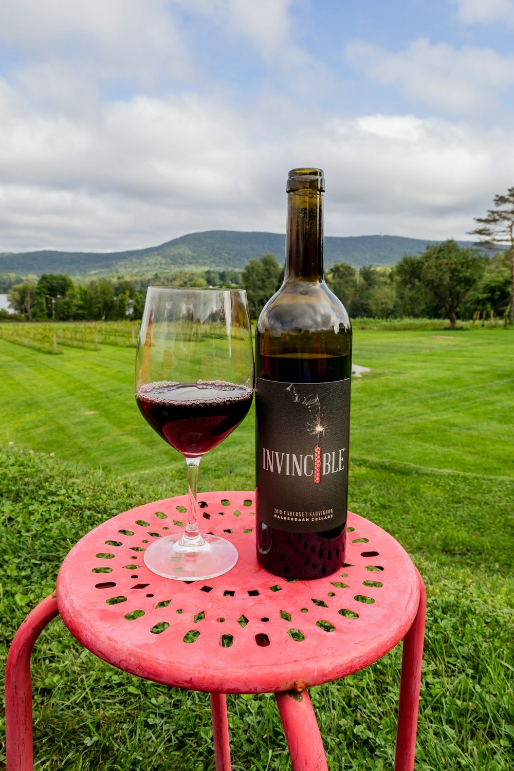 a bottle of wine sitting on top of a red table